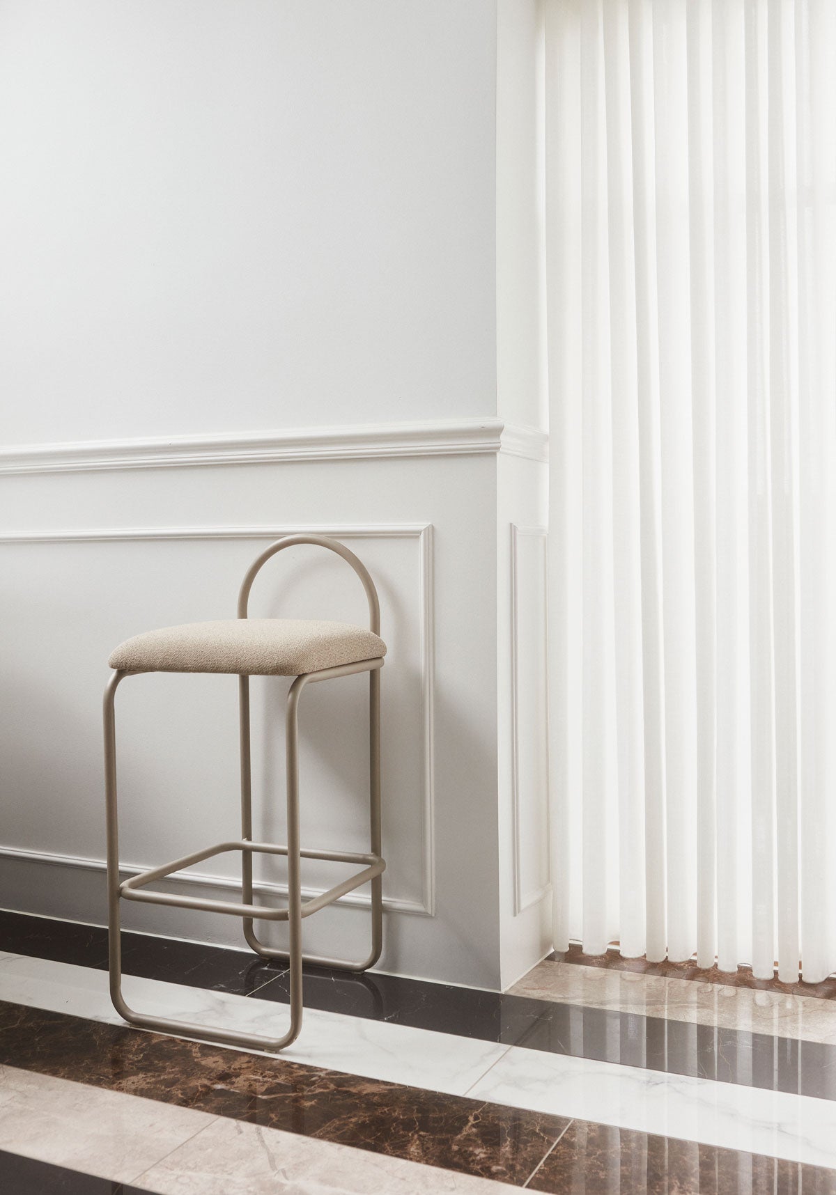 Angui Barstol Taupe Bouclé intill ett fönster med vita gardiner