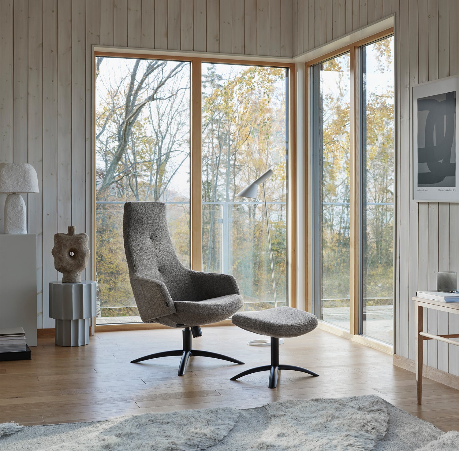 Joy Fåtölj med Fotpall i ljust vardagsrum med stora fönster