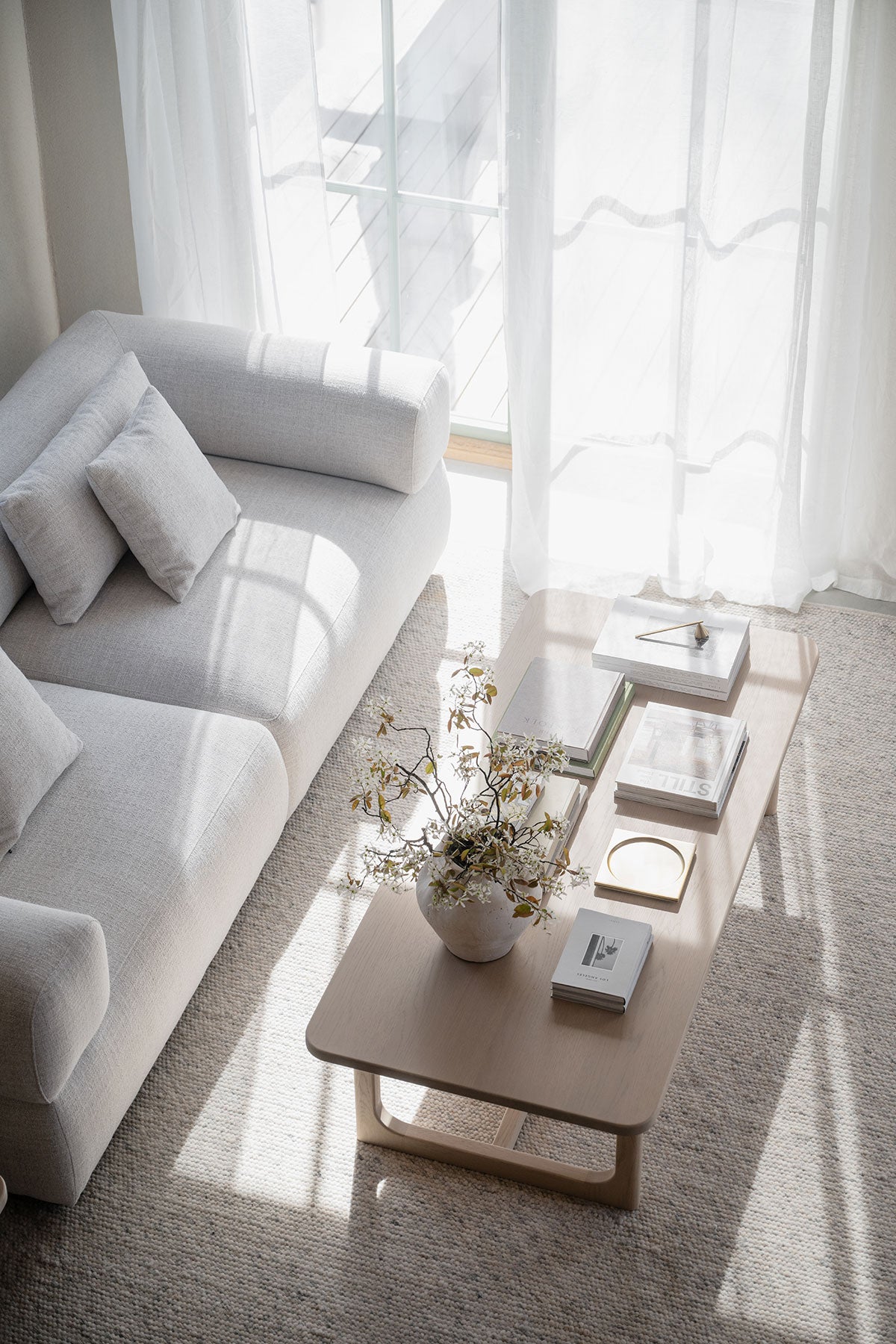 Driscoll Soffbord 160x70 i vitpigmenterad ek dekorerat med böcker och en kruka