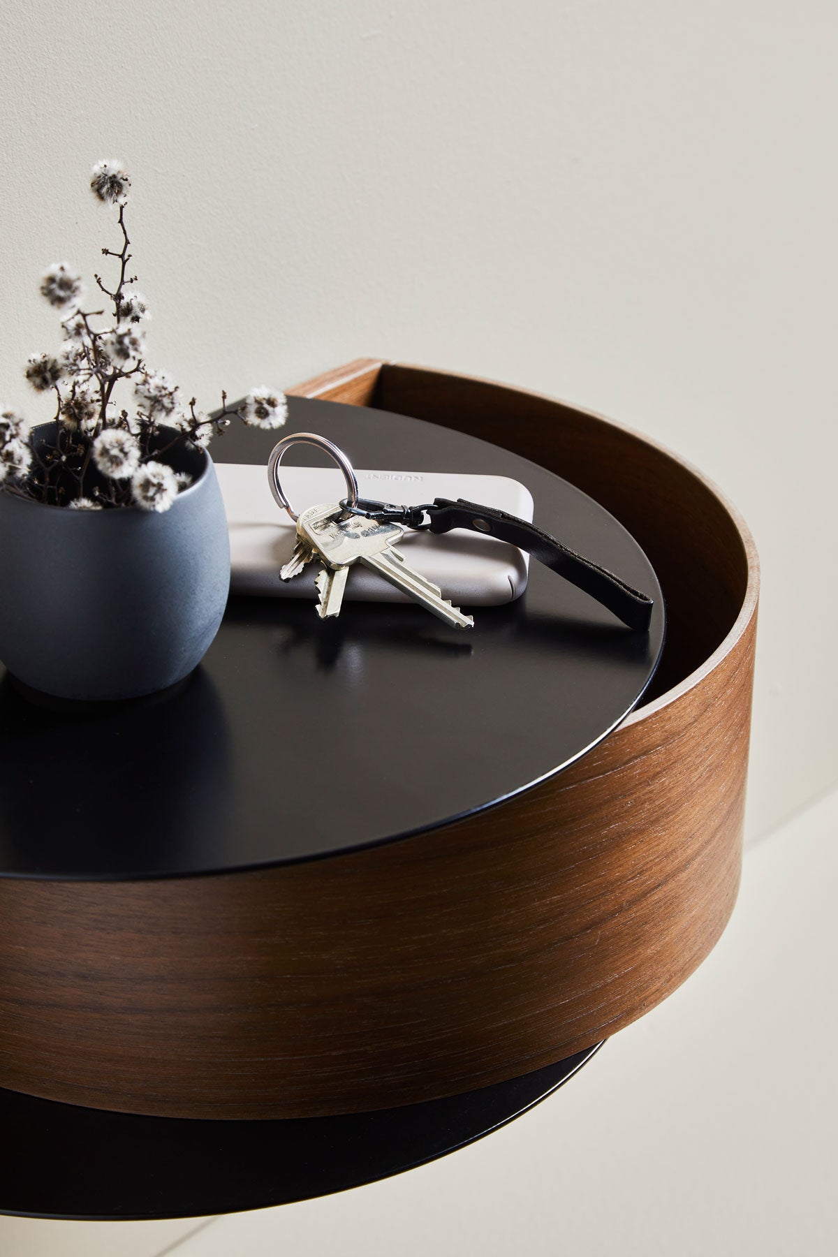 Wallie Vägghylla Valnöt / Svart med en blå kruka och ett par nycklar i hall