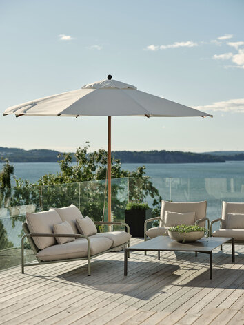 Lerberget Soffa och Fåtölj i grön färg på soligt trädäck med havsutsikt