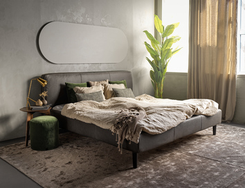 Shabby Sängram i sovrum med sidobord, spegel och krukväxt