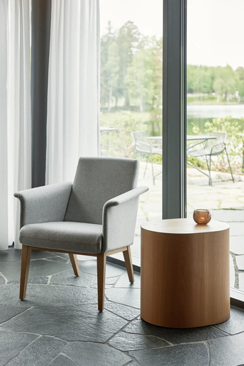 Miljöbild på fåtöljen Lazy, med förvaringsbordet Log. 