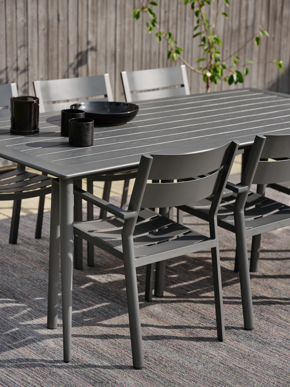 Nimes Matbord i färgen grå med stolar utomhus