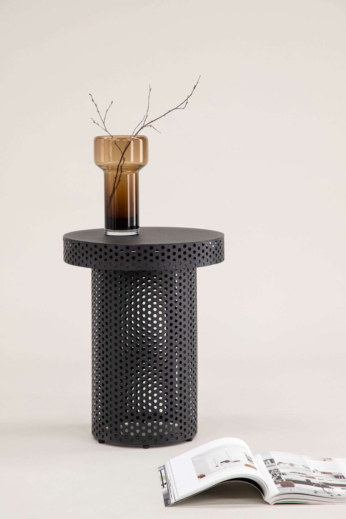 Bearsden Sidobord dekorerat med vas med kvistar bredvid ett uppslaget magasin