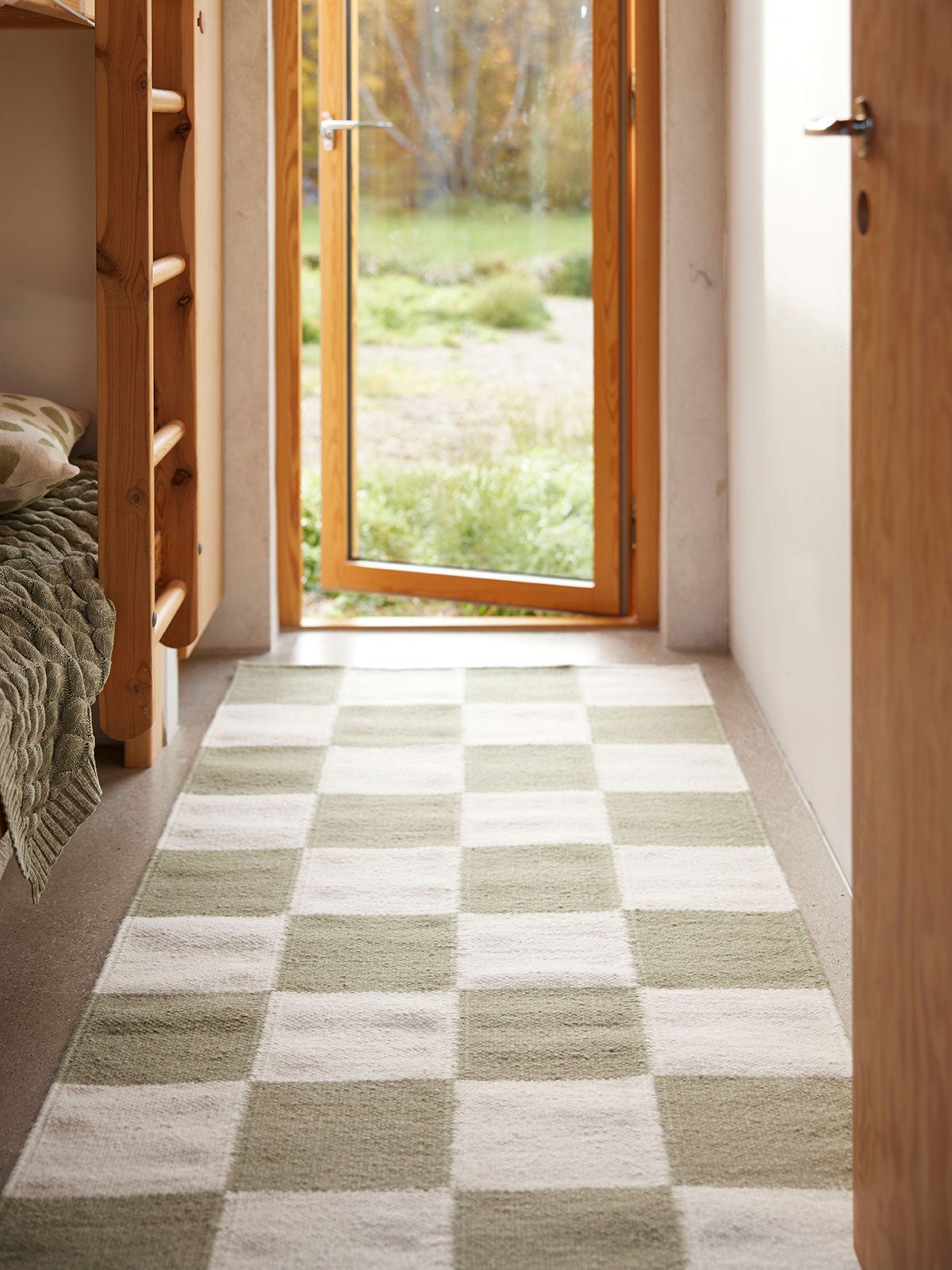 Squares Gångmatta i färgen Vit/Grön framför öppen dörr som vetter mot grönska