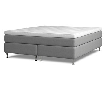 Kontinentalsängen Harmoni.  Bilden visar Harmoni med en bredd av 180 centimeter. Sängen är klädd i grått tyg. Benen är av förkromat stål. 