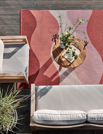 Urvi Matta i färgen Fire under soffgrupp utomhus